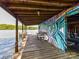 Covered waterfront dock with mural, seating, and storage, perfect for relaxing by the lake at 1278 Island Creek Dr, Troy, NC 27371