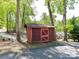 Quaint outdoor shed nestled among mature trees, adding storage and character to the property at 1278 Island Creek Dr, Troy, NC 27371