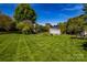 Spacious backyard featuring a well-manicured lawn, mature trees, and a defined perimeter fence for added privacy at 129 Morrison Cove Rd, Mooresville, NC 28117