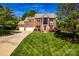 Beautiful brick home with manicured lawn and mature trees under a bright blue sky at 129 Morrison Cove Rd, Mooresville, NC 28117