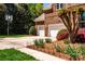 Three-car garage and basketball hoop, surrounded by lush landscaping and green lawn at 129 Morrison Cove Rd, Mooresville, NC 28117