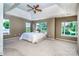Bright main bedroom with tray ceiling, ceiling fan, and large windows at 129 Morrison Cove Rd, Mooresville, NC 28117