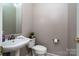 Powder room with pedestal sink, modern fixtures, and neutral decor at 129 Morrison Cove Rd, Mooresville, NC 28117