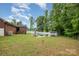 Large backyard with a fenced in yard, an in-ground pool, detached shed, and a brick house at 1376 Garland Ln, Lincolnton, NC 28092
