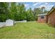 Spacious backyard with green lawn, a shed, fenced in yard and mature trees behind the house at 1376 Garland Ln, Lincolnton, NC 28092