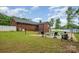 In-ground pool with patio furniture, fenced yard, lush lawn, and a brick home in the background at 1376 Garland Ln, Lincolnton, NC 28092