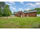 Expansive backyard view with an in-ground pool, brick house, and white picket fence at 1376 Garland Ln, Lincolnton, NC 28092