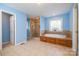 Bathroom featuring a shower and bathtub with tile surround, bright blue walls, and tiled floors at 1376 Garland Ln, Lincolnton, NC 28092