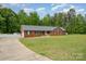 Lovely red brick home with attached garage, long driveway, and green lawn surrounded by beautiful trees at 1376 Garland Ln, Lincolnton, NC 28092