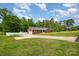 Inviting red brick home featuring an attached garage, long driveway, and pristine green lawn, perfect for outdoor enjoyment at 1376 Garland Ln, Lincolnton, NC 28092