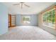 The spacious carpeted living room has large windows and a ceiling fan for comfort at 1376 Garland Ln, Lincolnton, NC 28092