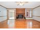 Sunlit living room with hardwood floors, a cozy brick fireplace, and French doors leading to another living space at 1376 Garland Ln, Lincolnton, NC 28092