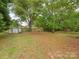 Large, expansive backyard with mature trees and partial fencing at 1438 Larkfield Ln, Charlotte, NC 28210