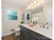 Bathroom featuring double sink vanity with modern fixtures and large, bright mirror at 1438 Larkfield Ln, Charlotte, NC 28210