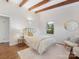 Bedroom featuring decorative wood beams, hardwood floors, a queen-sized bed and a sitting chair at 1438 Larkfield Ln, Charlotte, NC 28210