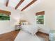 Cozy bedroom with exposed ceiling beams, hardwood floors, and bright natural light at 1438 Larkfield Ln, Charlotte, NC 28210
