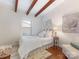 Bright bedroom featuring decorative wood beams, hardwood floors, and a cozy sitting area at 1438 Larkfield Ln, Charlotte, NC 28210