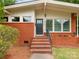Welcoming front entrance with brick steps, black front door, and manicured landscaping at 1438 Larkfield Ln, Charlotte, NC 28210