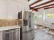 Well-lit kitchen featuring stainless steel appliances, white cabinets, and stylish backsplash at 1438 Larkfield Ln, Charlotte, NC 28210