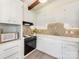 Well-lit kitchen boasts white cabinetry, tiled backsplash, and modern appliances for an updated look at 1438 Larkfield Ln, Charlotte, NC 28210
