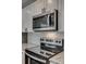 Close-up of a black stove top, stainless steel microwave, white cabinets, and granite countertops at 1495 Memorial Park Rd # 10, Lancaster, SC 29720