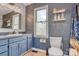 Charming bathroom featuring blue cabinetry, a window, and unique patterned wallpaper at 1522 Stafford Ext, Monroe, NC 28110