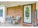 Inviting front porch with comfortable wicker chairs, a welcome sign, and brick detailing at 1623 Mulberry Cir, Rock Hill, SC 29730