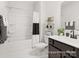 Modern bathroom with a shower-tub combination, dark vanity, and stylish shelves adorned with greenery at 181 Montgomery Pl # 726, Mount Gilead, NC 27306