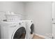 Functional laundry room with washer, dryer, and storage shelves at 1849 Fleetwood Dr, Charlotte, NC 28208
