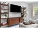 Modern living room featuring shelving, a mounted TV, and comfortable seating at 1849 Fleetwood Dr, Charlotte, NC 28208