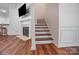 Open-concept living room featuring hardwood floors, fireplace, and staircase at 1863 New Castle Dr, Fort Mill, SC 29707