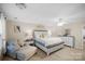 Bright main bedroom features a seating area, ceiling fan, and a large dresser with mirror at 1988 Clear Brooke Dr, Kannapolis, NC 28083