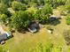Aerial view of a property showcasing a house with green lawn, mature trees, a shed, and adjacent buildings at 2007 Green Peach Rd, Lancaster, SC 29720