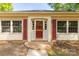 Charming home entrance with a brick walkway, red shutters and a red door flanked by sidelight windows at 2007 Green Peach Rd, Lancaster, SC 29720