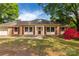 Charming single-story home featuring red shutters, brick accents, a well-maintained yard, and a beautiful red azalea bush at 2007 Green Peach Rd, Lancaster, SC 29720