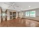 The spacious living room features wood floors, a ceiling fan, built-in shelving and cabinets, and large windows at 2007 Green Peach Rd, Lancaster, SC 29720
