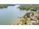 Aerial view showcasing the waterfront property with a private dock, lush greenery, and stunning lake at 202 Timber Lake Dr, Troutman, NC 28166