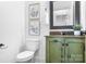 Charming powder room featuring a distressed green vanity, granite countertop, framed botanical prints, and decorative mirror at 202 Timber Lake Dr, Troutman, NC 28166