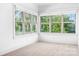 Sunlit bedroom with multiple windows offers picturesque views of the surrounding landscape and features neutral carpeting at 202 Timber Lake Dr, Troutman, NC 28166