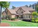 Stunning home featuring a stone and stucco facade, mature landscaping, and a welcoming front porch at 202 Timber Lake Dr, Troutman, NC 28166