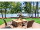 Outdoor patio area with a stone fire pit and comfortable seating, overlooking the serene lake at 202 Timber Lake Dr, Troutman, NC 28166