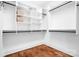 Spacious walk-in closet with custom shelving, drawers, and wood floors provides an organized storage solution at 202 Timber Lake Dr, Troutman, NC 28166