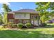 Expansive backyard of a brick home featuring a deck, large windows, manicured shrubs, and a well-maintained lawn at 204 Limerick Dr, Matthews, NC 28104