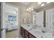 This bathroom with wood cabinets features a large mirror and is next to the bedroom at 204 Limerick Dr, Matthews, NC 28104