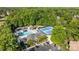 Aerial shot of community amenities, including a pool, tennis courts, playground, and clubhouse, surrounded by lush trees at 204 Limerick Dr, Matthews, NC 28104