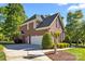 A side view of a brick two-story home showing the garage and long driveway at 204 Limerick Dr, Matthews, NC 28104