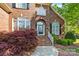 Charming brick home with an arched doorway, complemented by mature landscaping and a well-manicured walkway at 204 Limerick Dr, Matthews, NC 28104