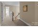 Hallway featuring neutral walls, wood banister, carpet floor, and access to the bedrooms at 204 Limerick Dr, Matthews, NC 28104