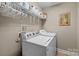 Functional laundry room with washer, dryer, and overhead storage shelving at 204 Limerick Dr, Matthews, NC 28104