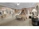 This main bedroom boasts a sitting area, canopy bed, neutral walls, and carpet throughout at 204 Limerick Dr, Matthews, NC 28104